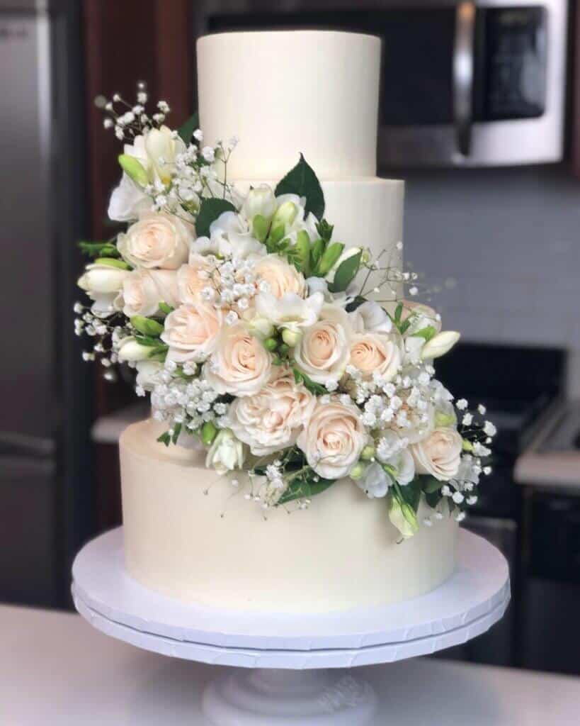 image of wedding cake with fresh white and green florals