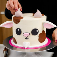 image of an adorable goat cake made with buttercream and a fondant face