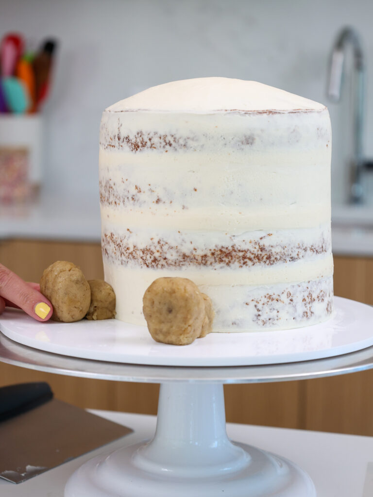 image of a crumb coated cake that's had legs pressed onto it made from cake pops