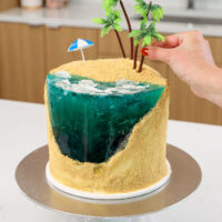 image of palm trees being pressed into place on a cute summer beach cake