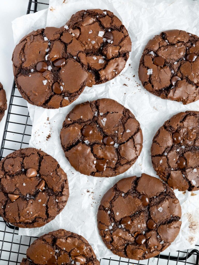 image of brownie crinkle cookies that are cooling on parchment paper