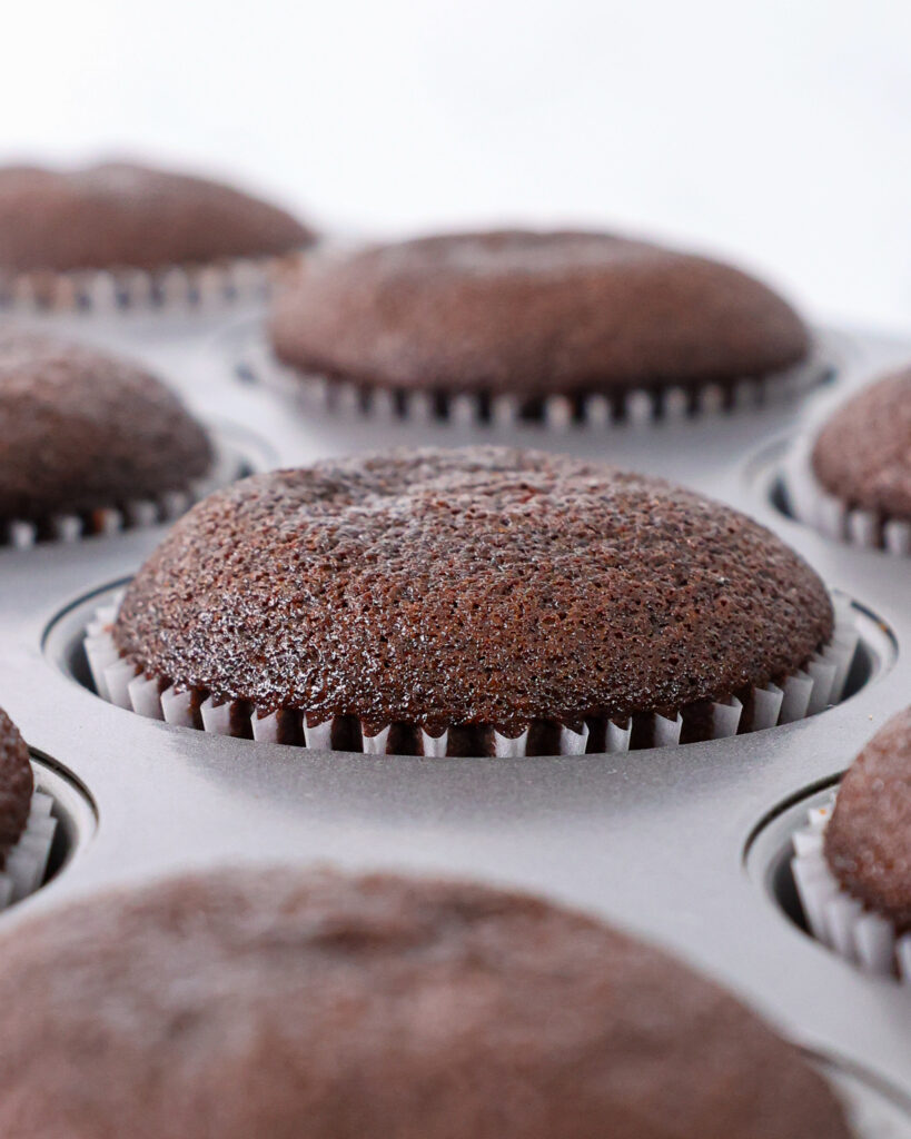 image of baked chocolate cupcakes cooling in a cupcake pan