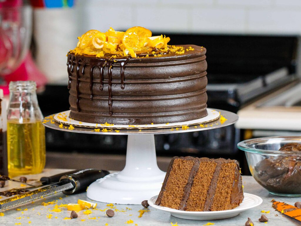 image of chocolate orange cake with slice in front on a plate showing how fluffy and tender the cake layers are