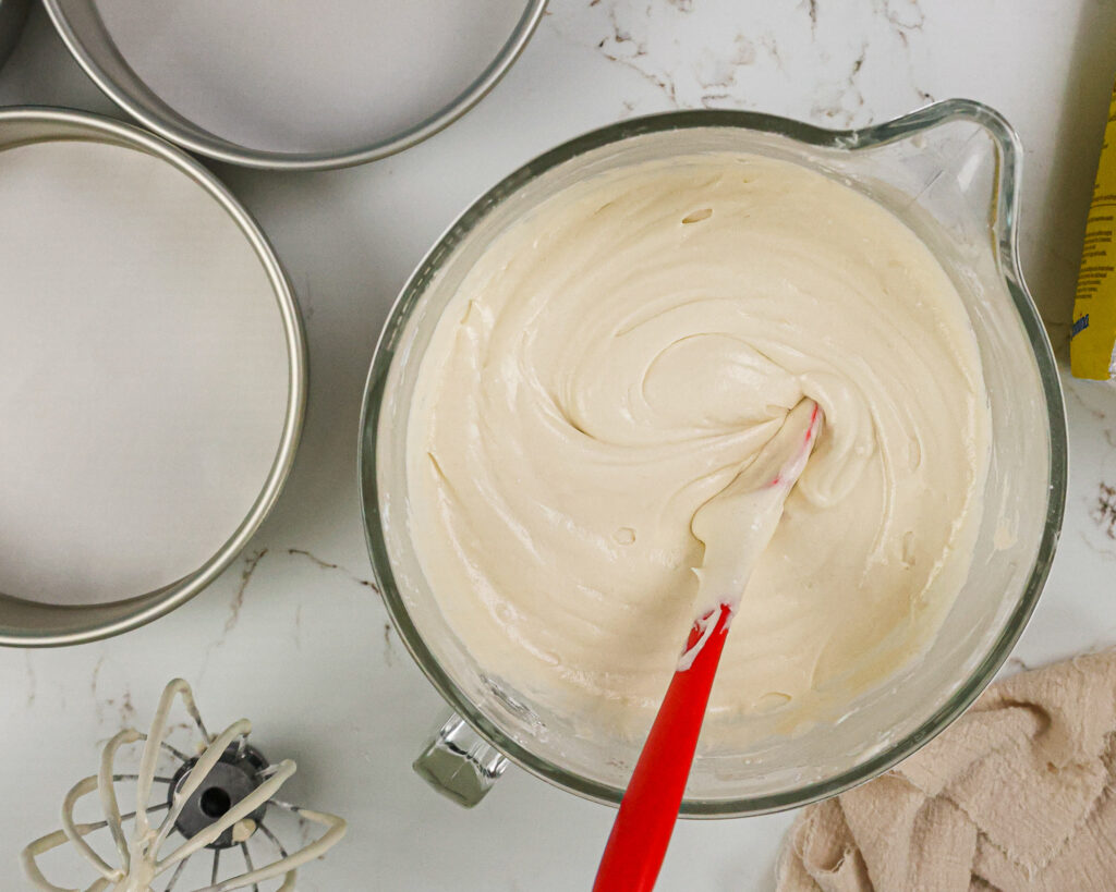 image of fluffy vanilla cake batter being mixed and that's ready to be poured into the prepared pans to be baked