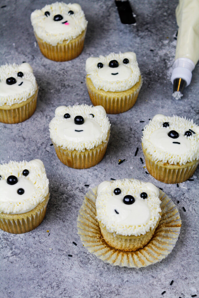 image of an easy polar bear cupcakes made with buttercream frosting and black sprinkles