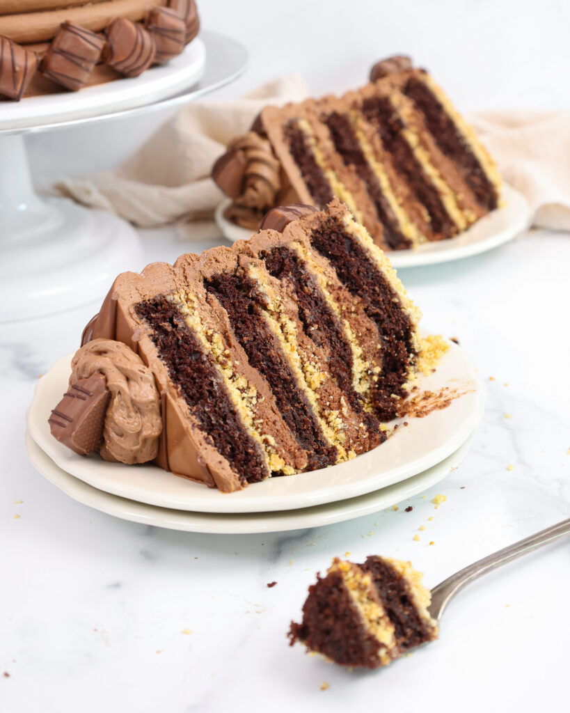 image of a kinder bueno cake slice that's been cut into with a fork to show how moist and delicious it is