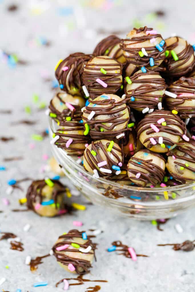 image of edible cookie dough bites on a wire rack that have been drizzled with melted chocolate