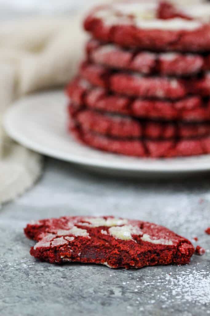 image of a red velvet crinkle cookie that's been bitten into to show it's soft and chewy center