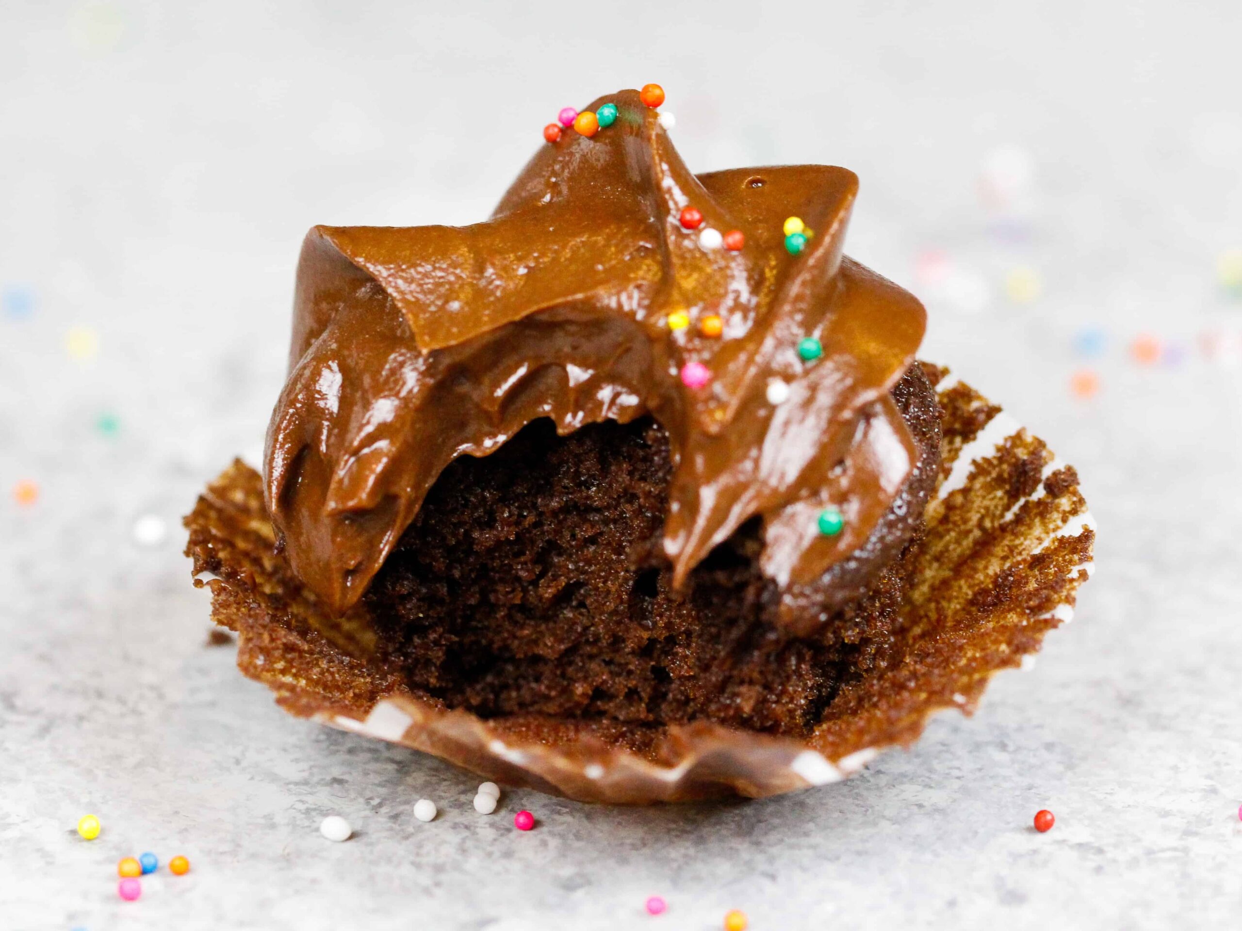 image of a mini chocolate cupcake that's been bitten into to show how moist it is