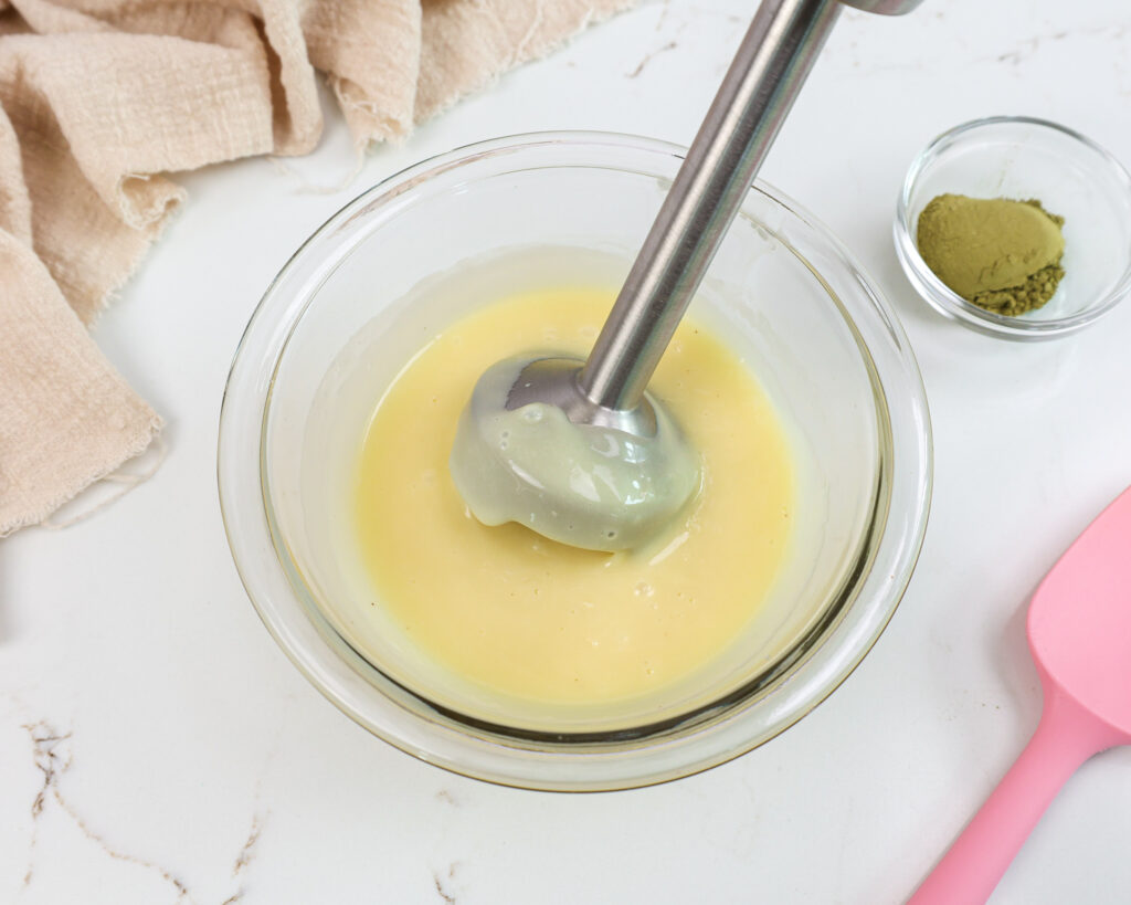 image of white chocolate ganache being blended with an immersion blender to make it super smooth before adding in matcha powder