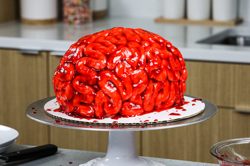 image of a bloody brain cake made for halloween with red velvet cake layers and raspberry jam blood