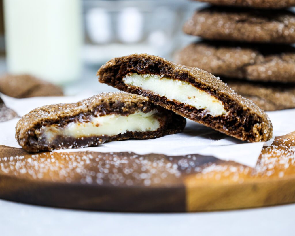 image of a chocolate cheesecake cooke that's been bitten into to show its creamy cheesecake filling