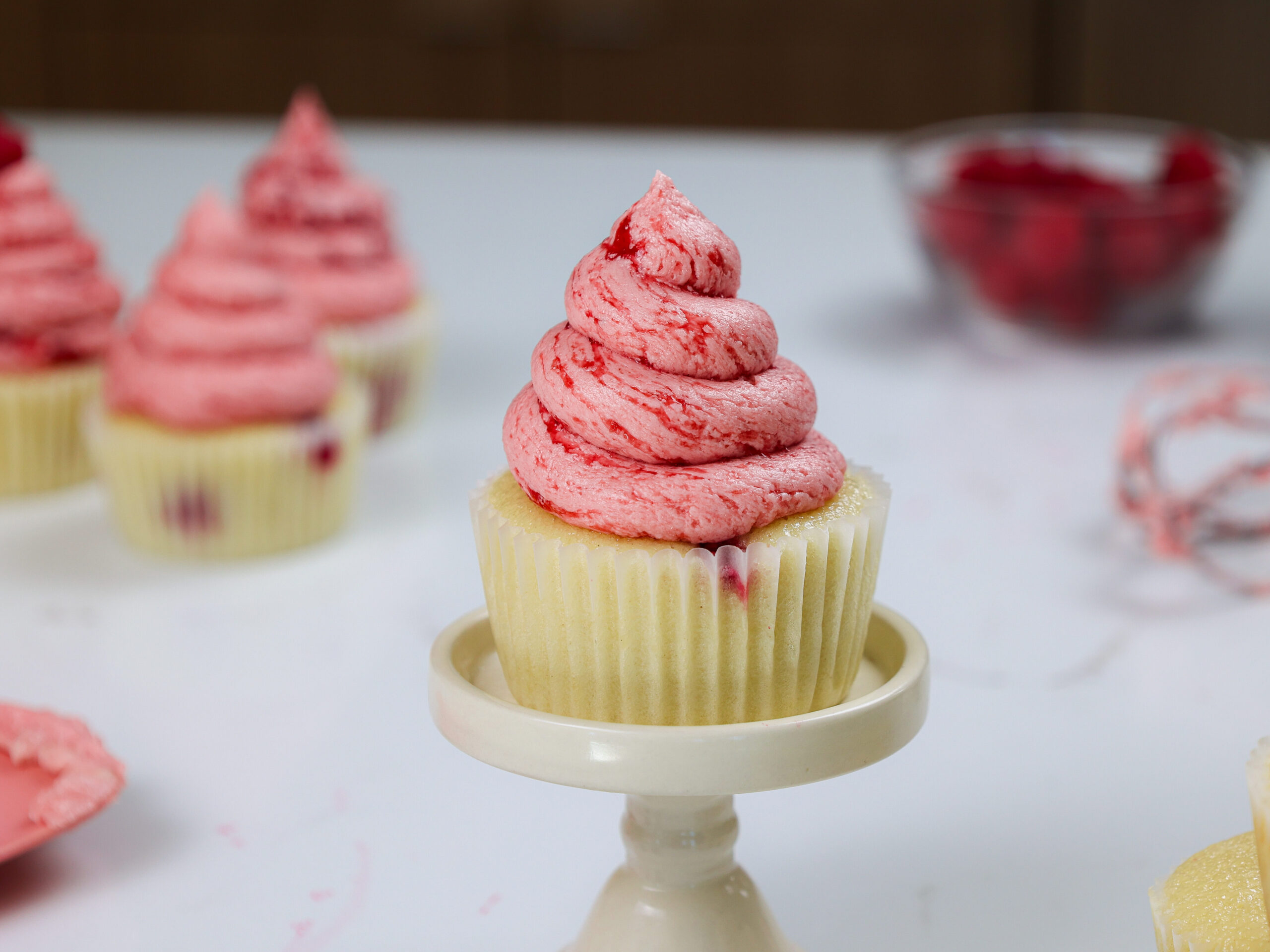 image of raspberry cupcakes made with vanilla cupcakes and raspberry buttercream