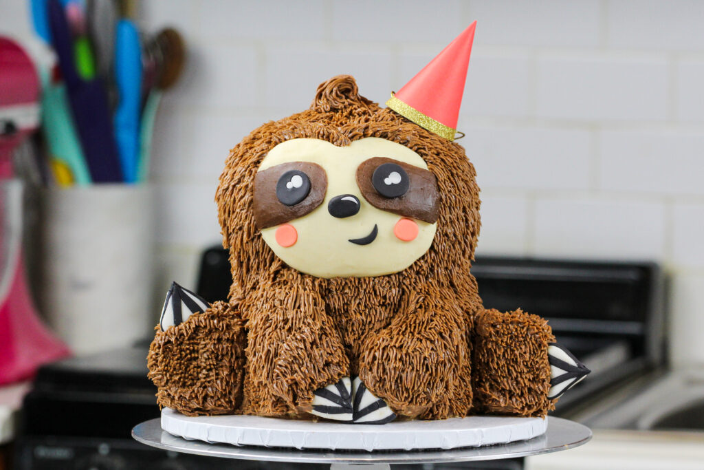 image of a sloth birthday cake made with chocolate cake layers and chocolate peanut butter buttercream