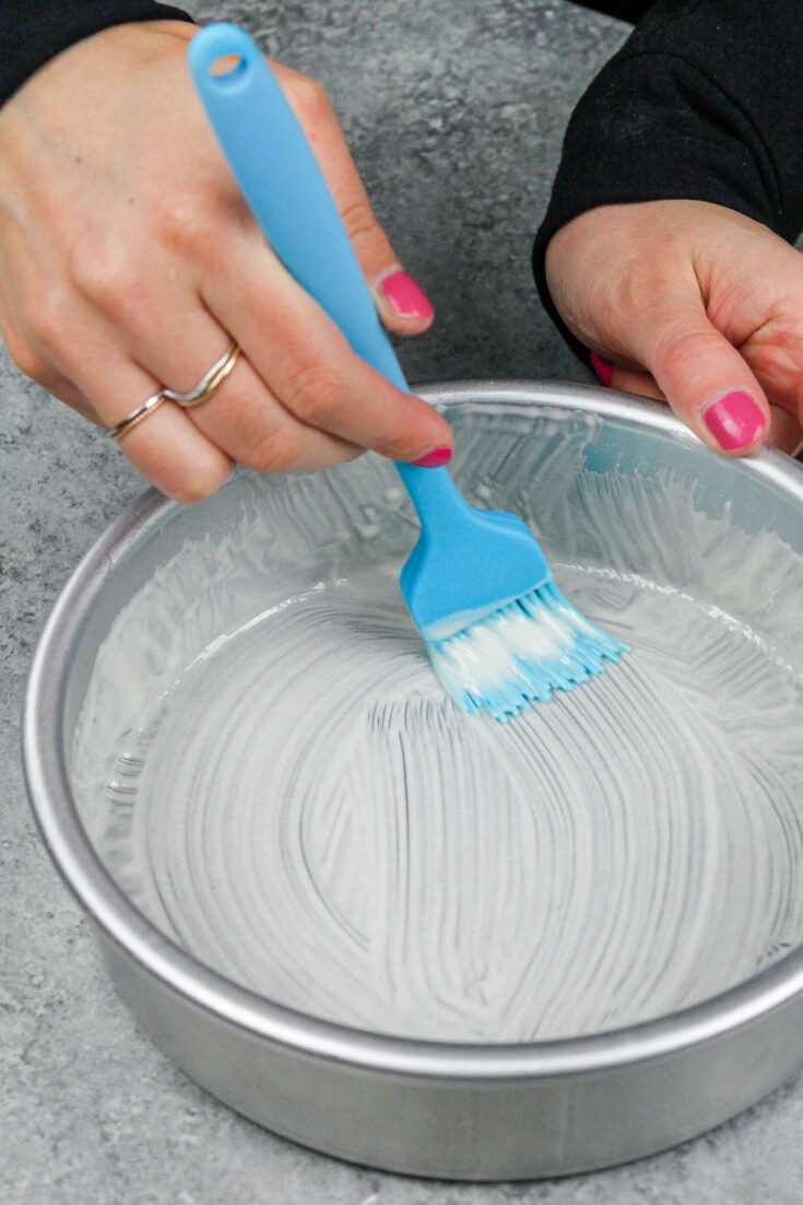 image of homemade cake release being brushed into a cake pan before batter is poured in to prevent the cake layers from sticking