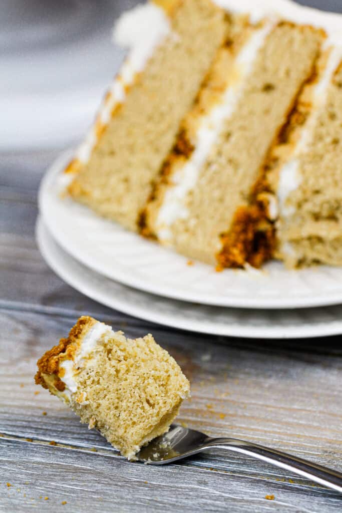 image of a bite of cookie butter cake on a fork next to its slice