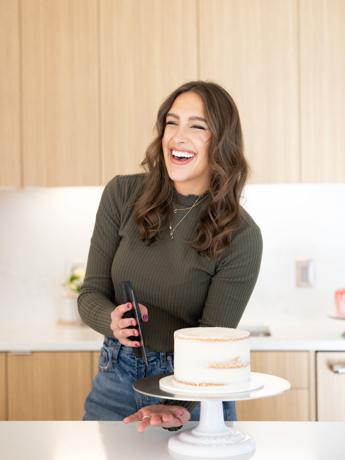 image of chelsey white of chelsweets crumb coating a cake with a bench scraper