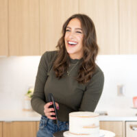 image of chelsey white of chelsweets crumb coating a cake with a bench scraper