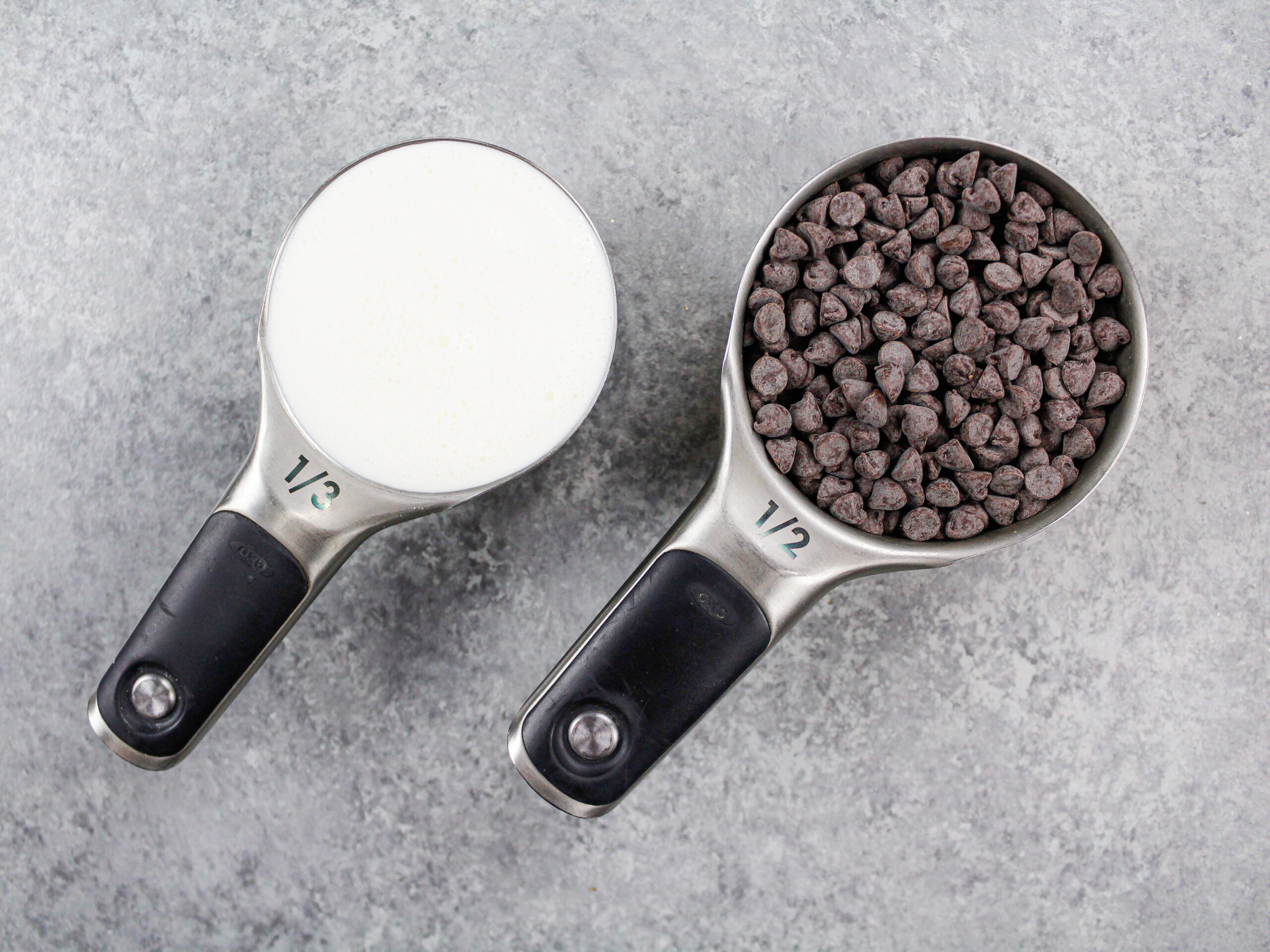 image of chocolate chips and heavy cream laid out on a counter to make a chocolate ganache drip for a chocolate cake