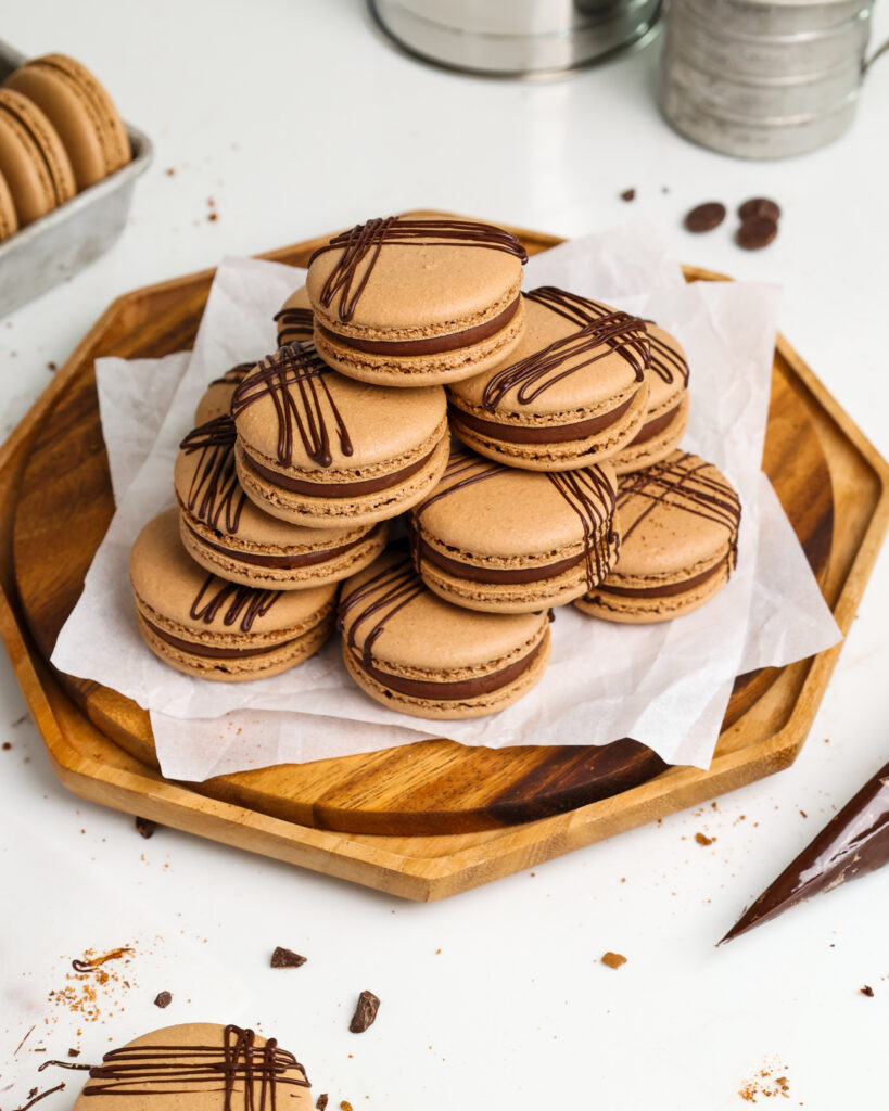 image of a french chocolate macaron being filled with a semi sweet chocolate ganache