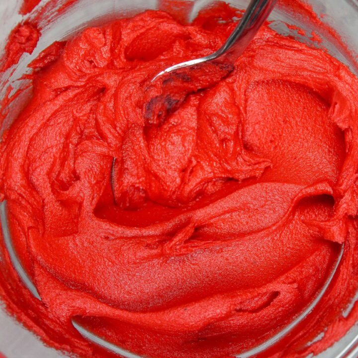 image of red buttercream frosting in a bowl