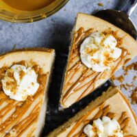 image of biscoff cheesecake that's been drizzled with warm cookie butter and topped with whipped cream