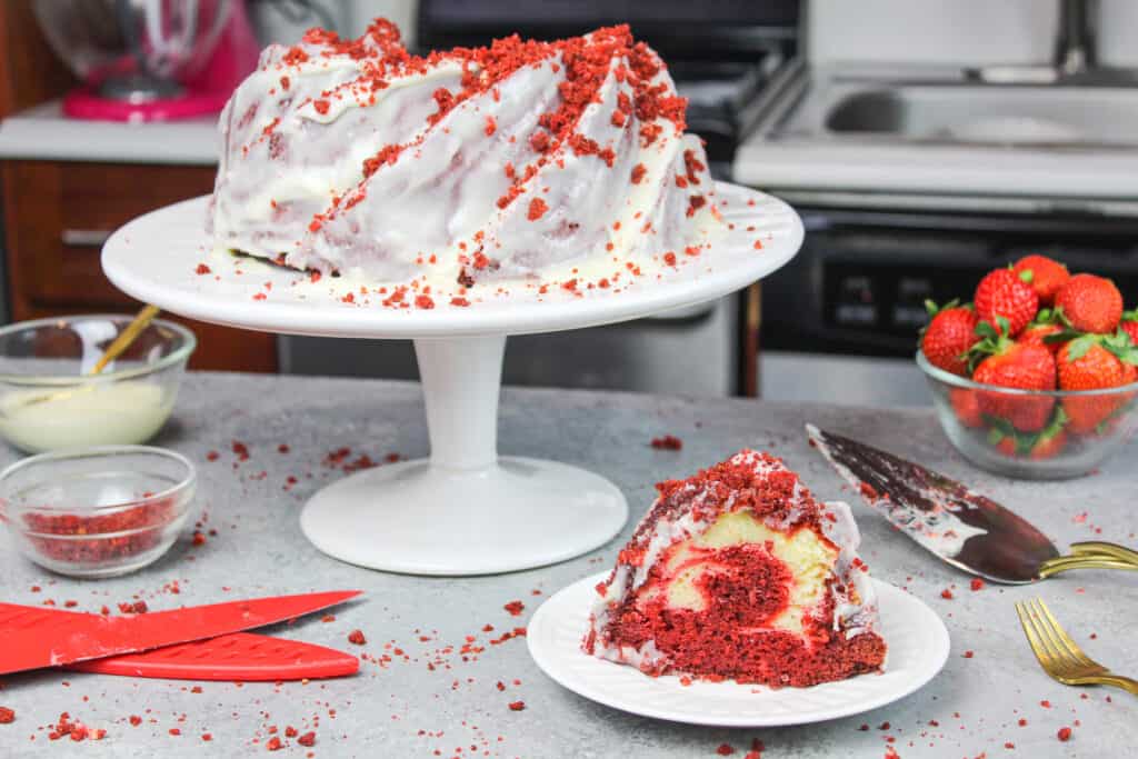 image of red velvet bundt cake, sliced with a cream cheese glaze icing