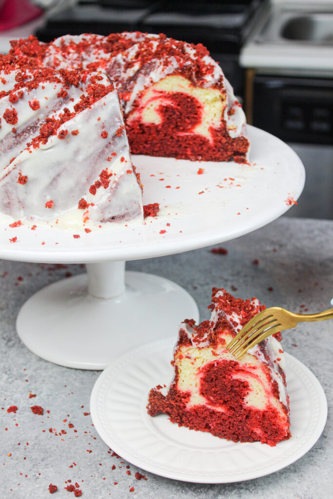 image of a red velvet bundt cake, sliced to show the cream cheese ripple swirled through the middle