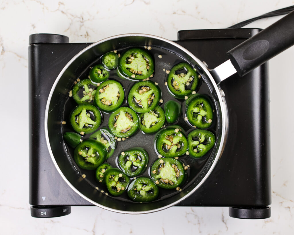 image of jalapeno simple syrup that's being cooked down in a saucepan