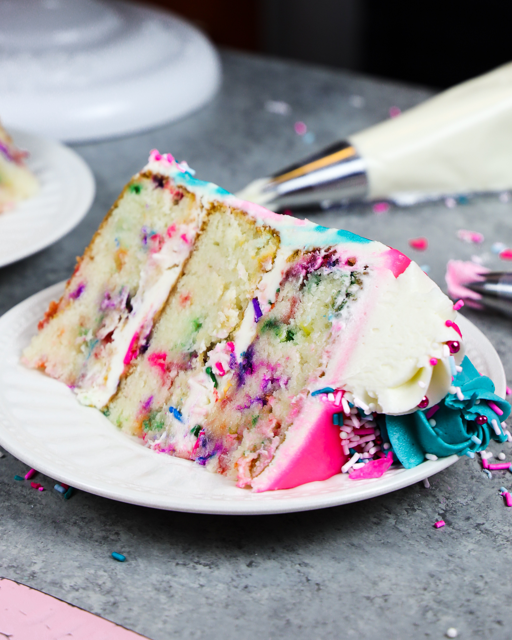 image of a slice of gluten free funfetti cake on a plate ready to be eaten