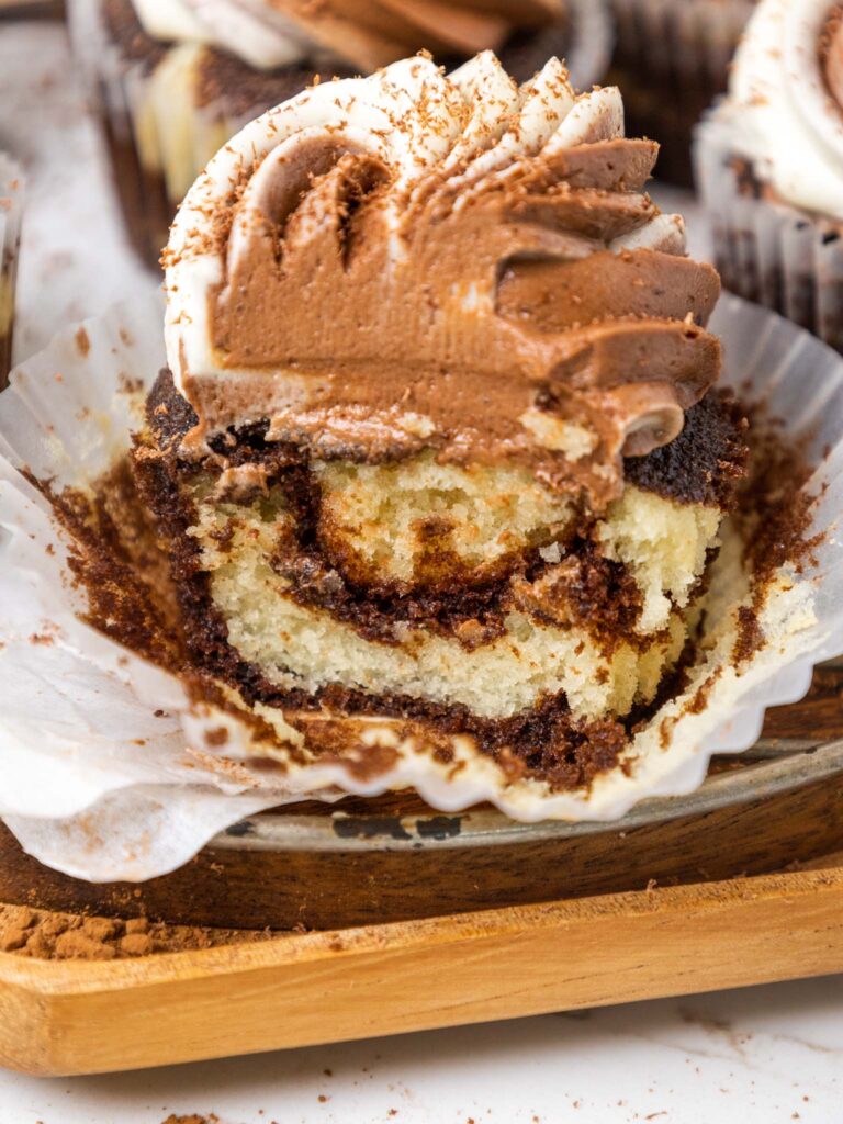 image of a marble cupcake that's been bitten into to show how moist and tender it is