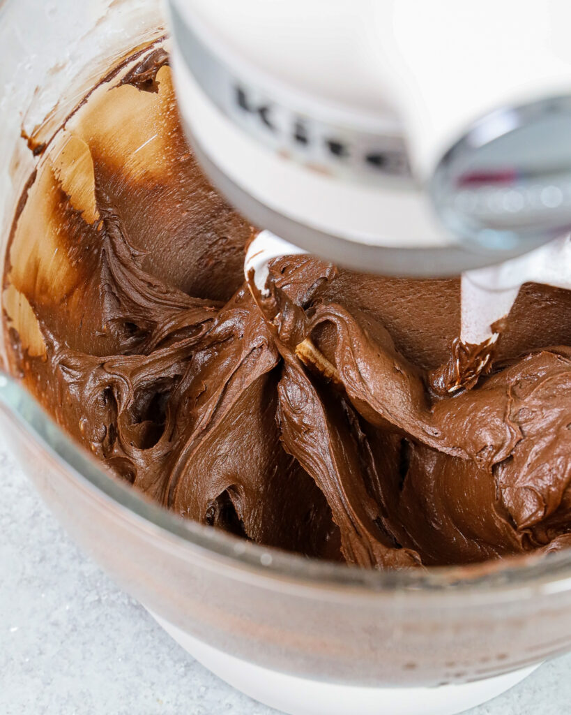 image of a small batch of dark chocolate buttercream that's been mixed and is ready to be used to frost a cake