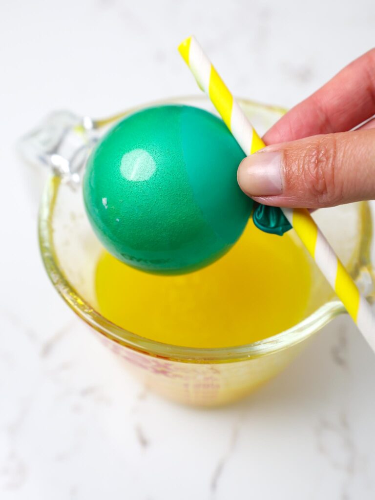 image of a yellow gelatin bubble being made with a small teal balloon
