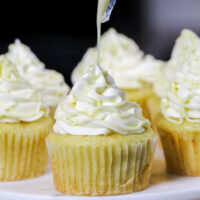 image of white chocolate cupcakes being topped with a drizzle of melted white chocolate