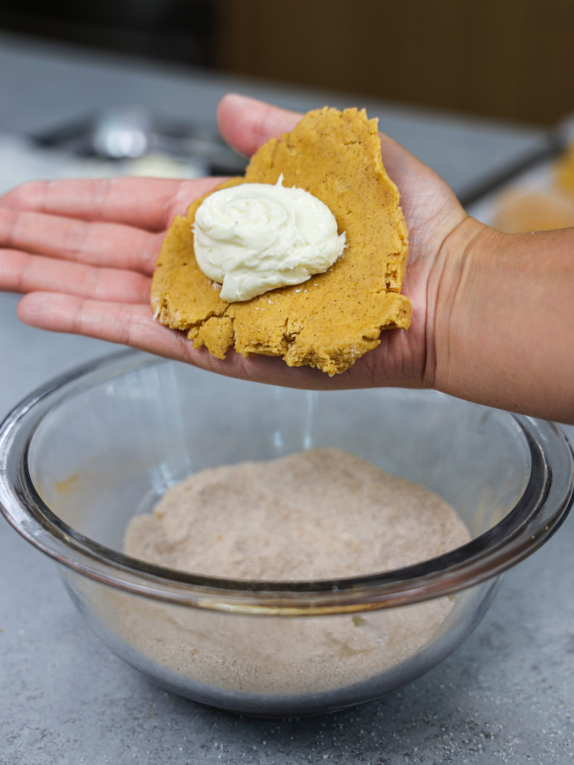 image of pumpkin cookie dough that's being filled with cheesecake filling
