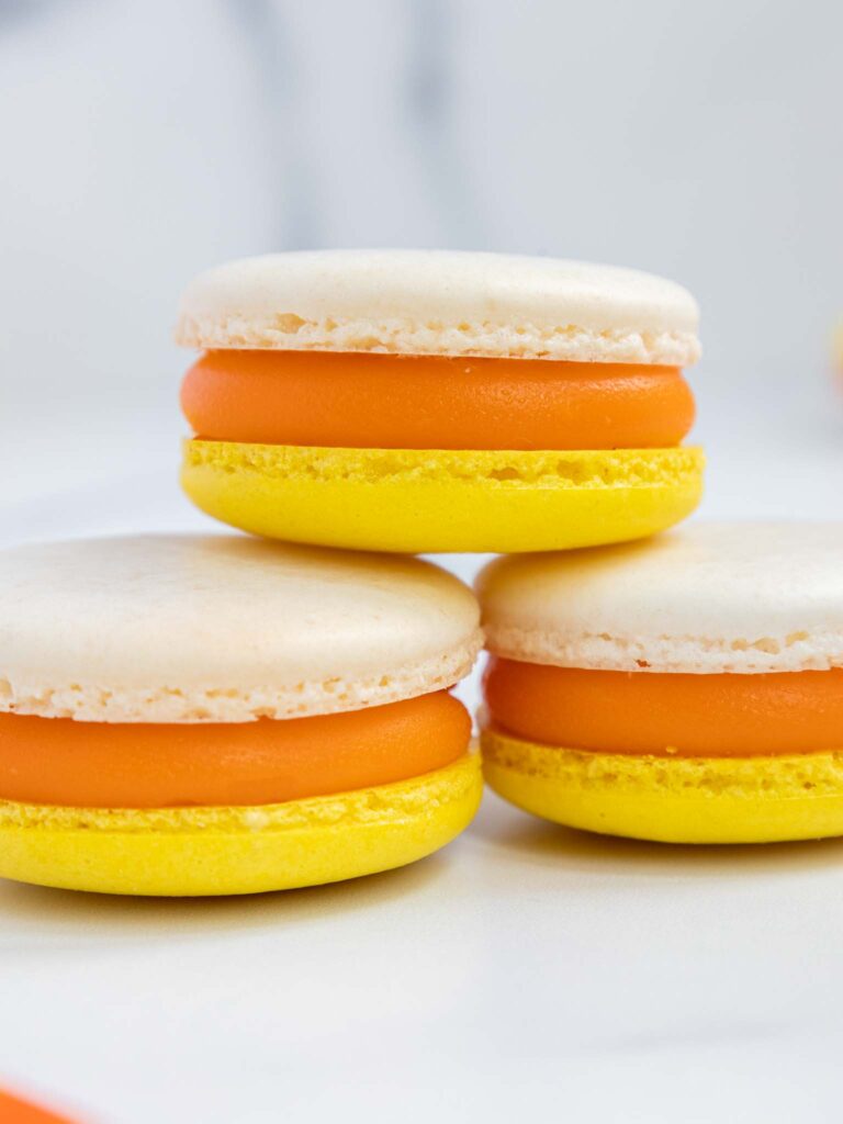 image of candy corn macarons that have been filled with candy corn ganache