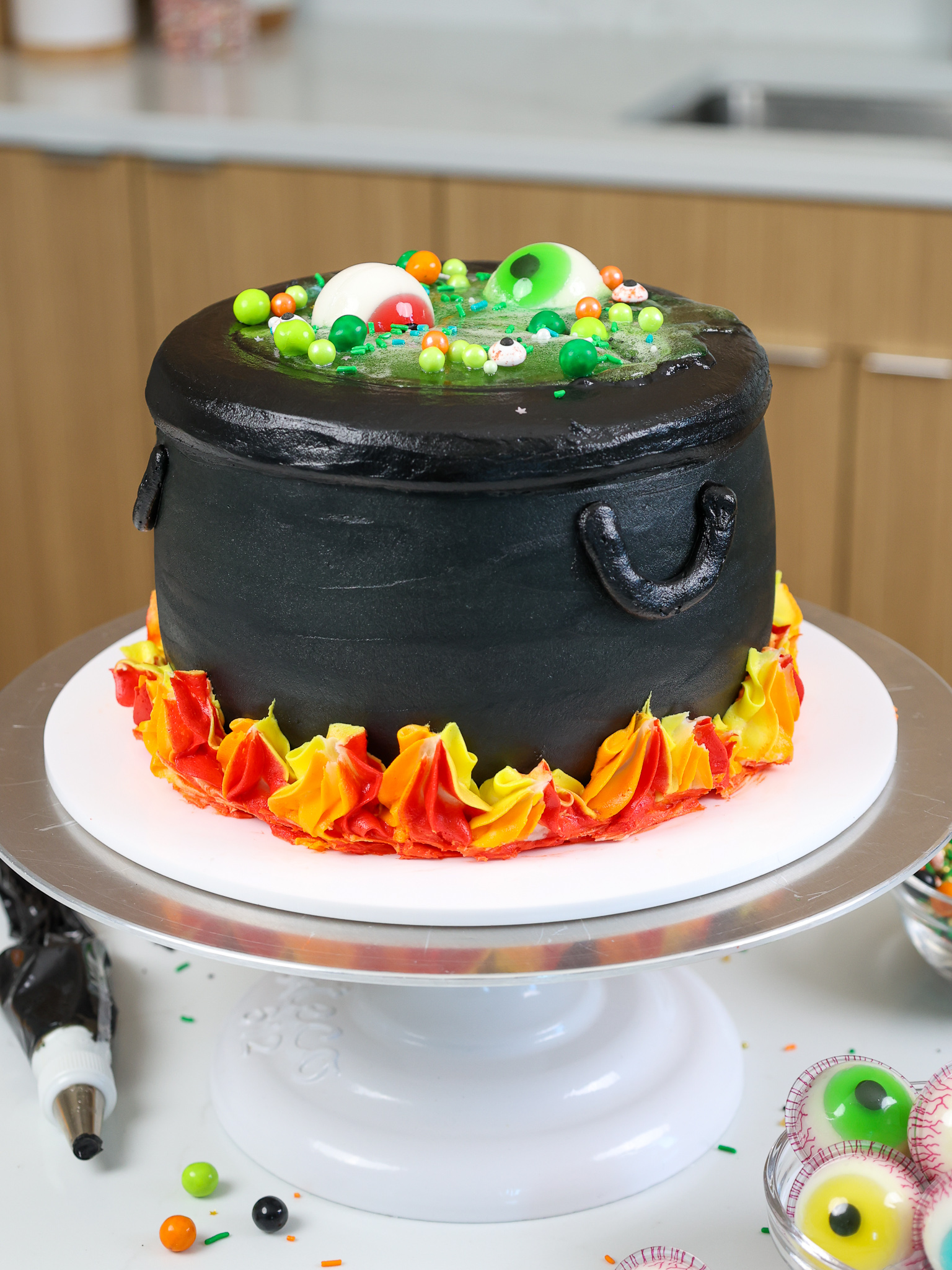 image of a cauldron cake made with black cocoa frosting and cake layers and a jello potion center