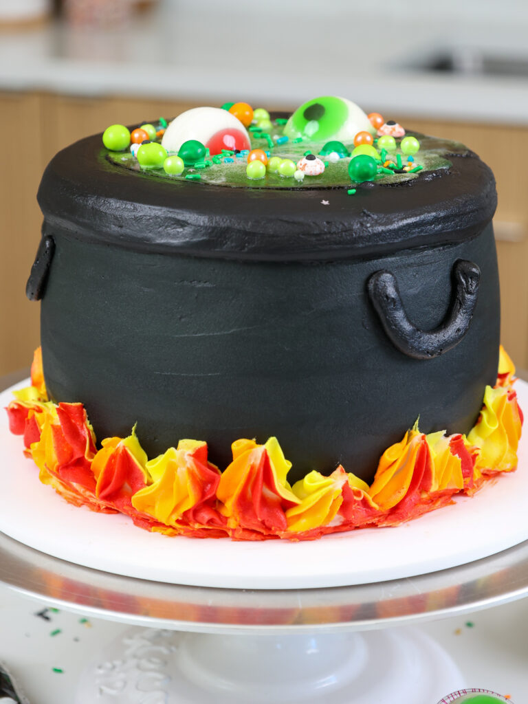 image of a cauldron cake made with black cocoa frosting and cake layers and a jello potion center