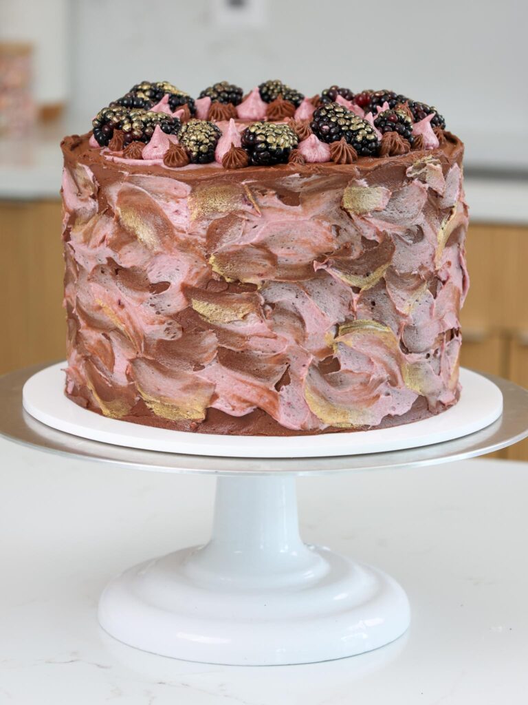image of a beautiful chocolate blackberry cake that's been decorated with fresh blackberries and edible gold paint