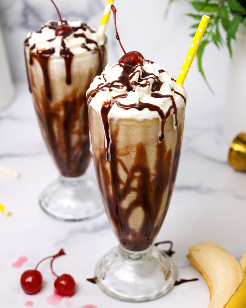 image of a dirty monkey drink that's been made with rum and bananas and has been poured into a chocolate syrup lined milkshake glass that's shared as part of a no bake recipe round up