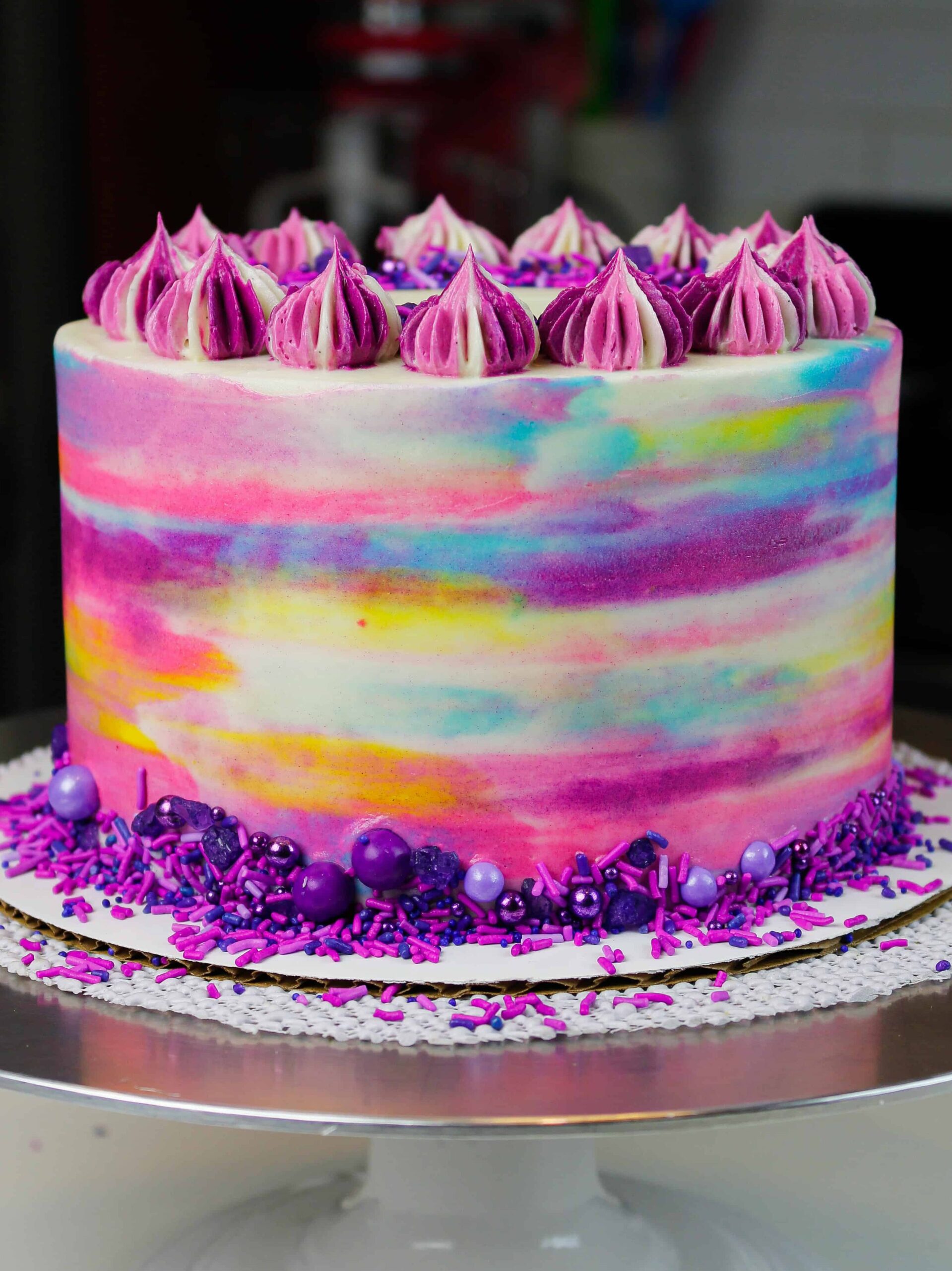 image of frosted vegan cake decorated to look like a watercolor painting with colorful frosting