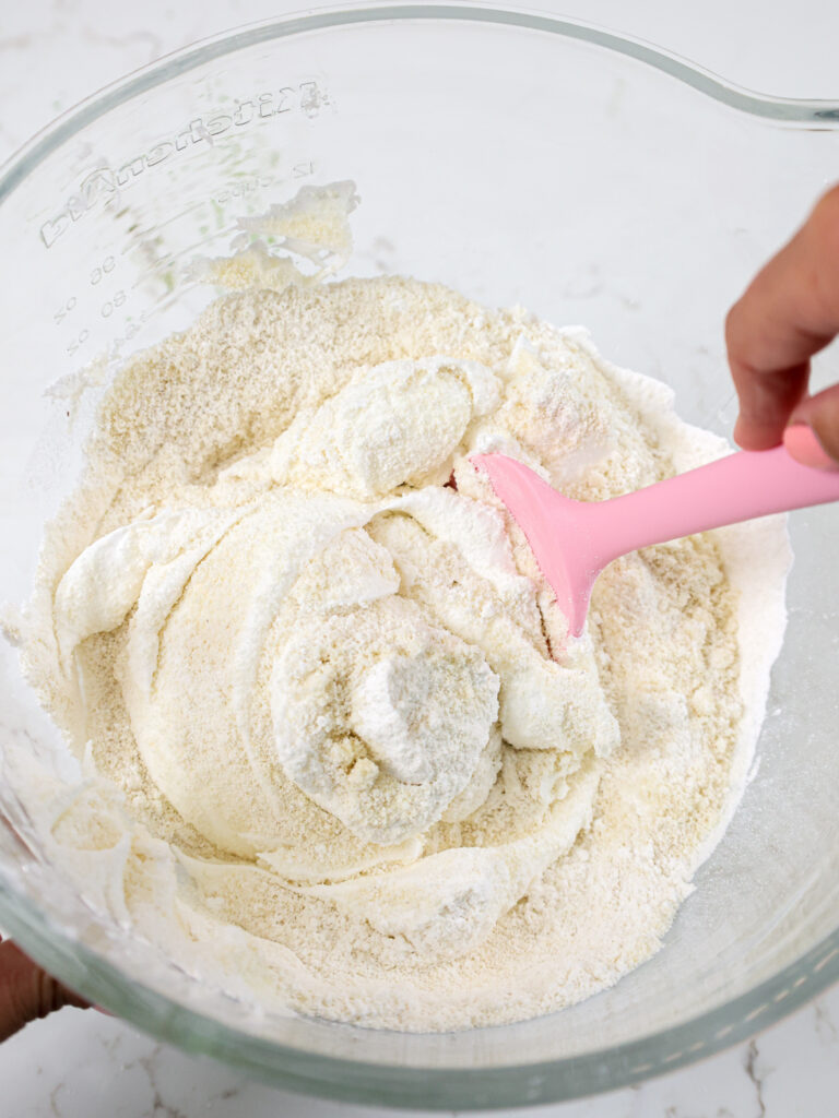 image of dry ingredients being folded into meringue to make macaron batter