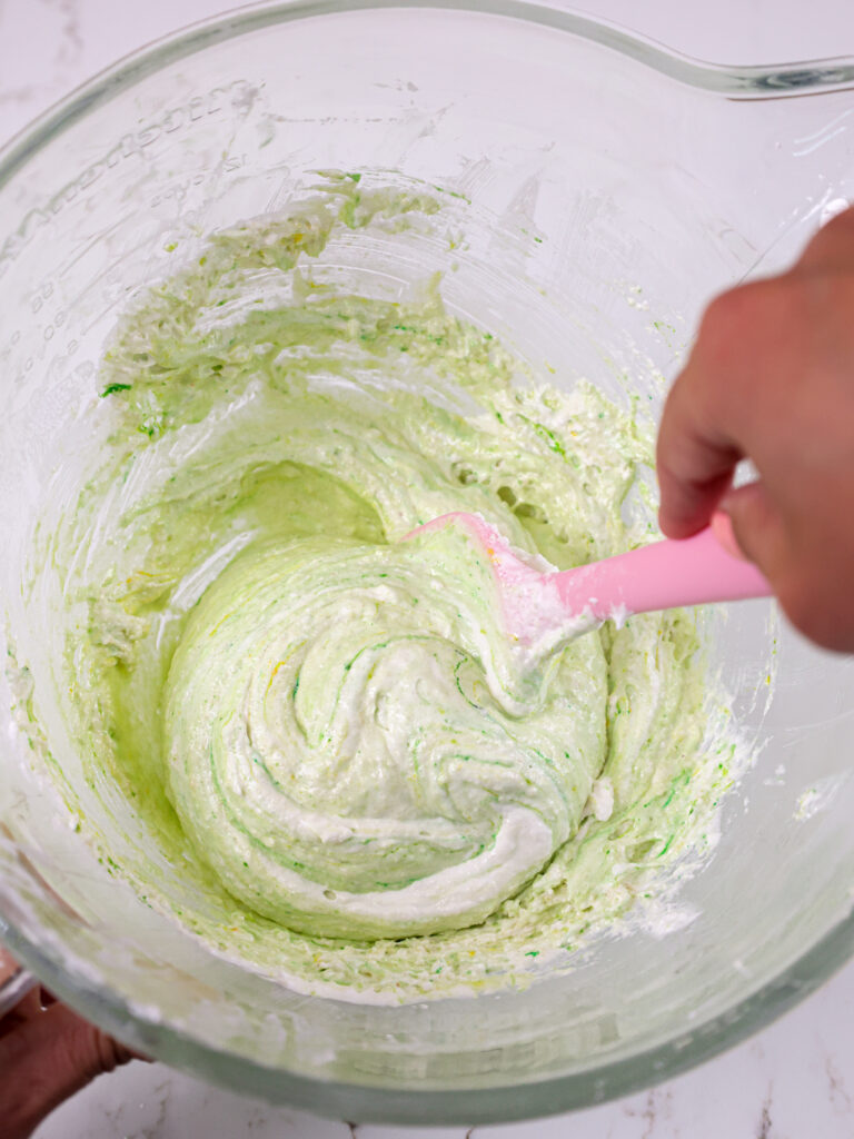 image of macaron batter being folded to incorporate the dry ingredients