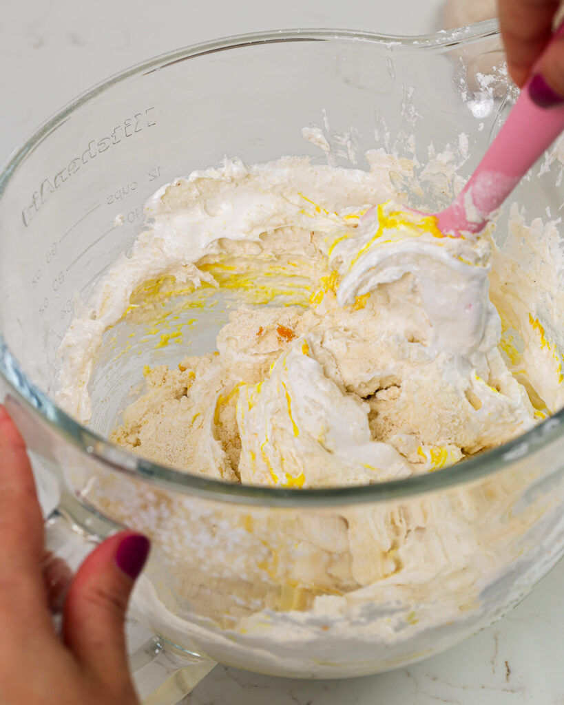 image of macaron batter being folded together with a rubber spatula during macaronage