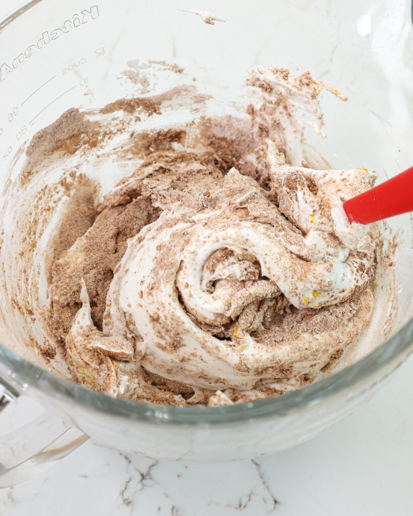 image of dry ingredients being folded into french meringue to make chocolate macaron shells