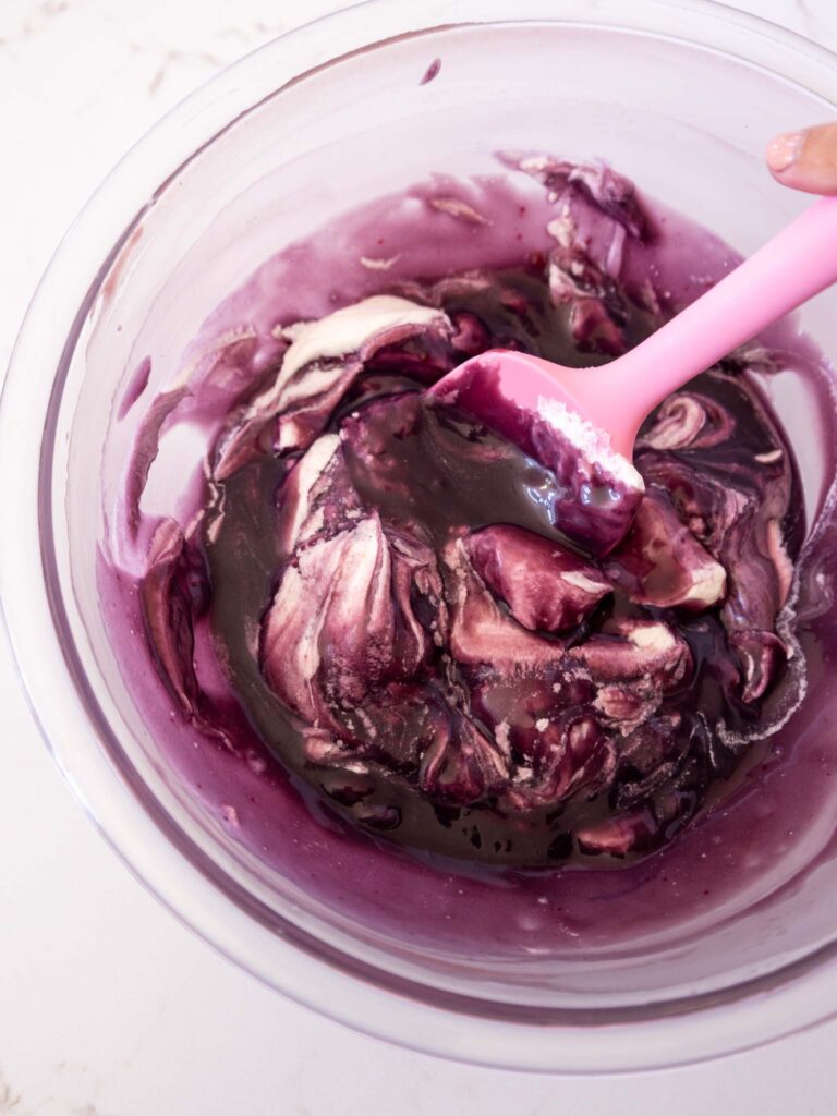 image of whipped cream being folded into blackberry ganache