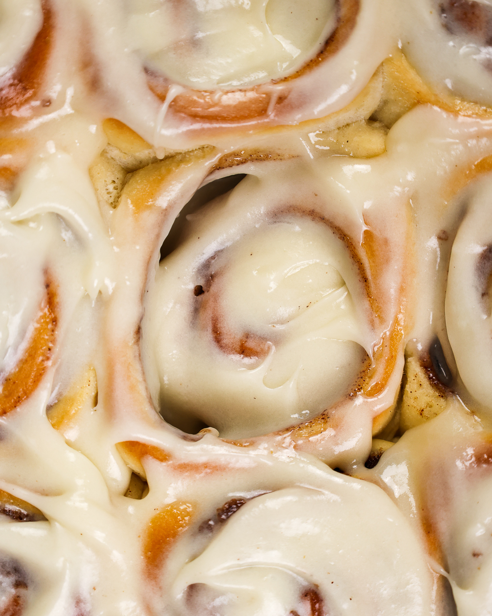 image of frosted quick yeast cinnamon rolls that have been slathered with cream cheese frosting