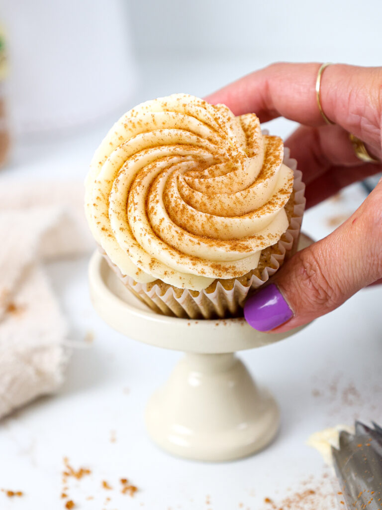 image of a spice cupcake being held at an angle to show it's delicious cream cheese frosting