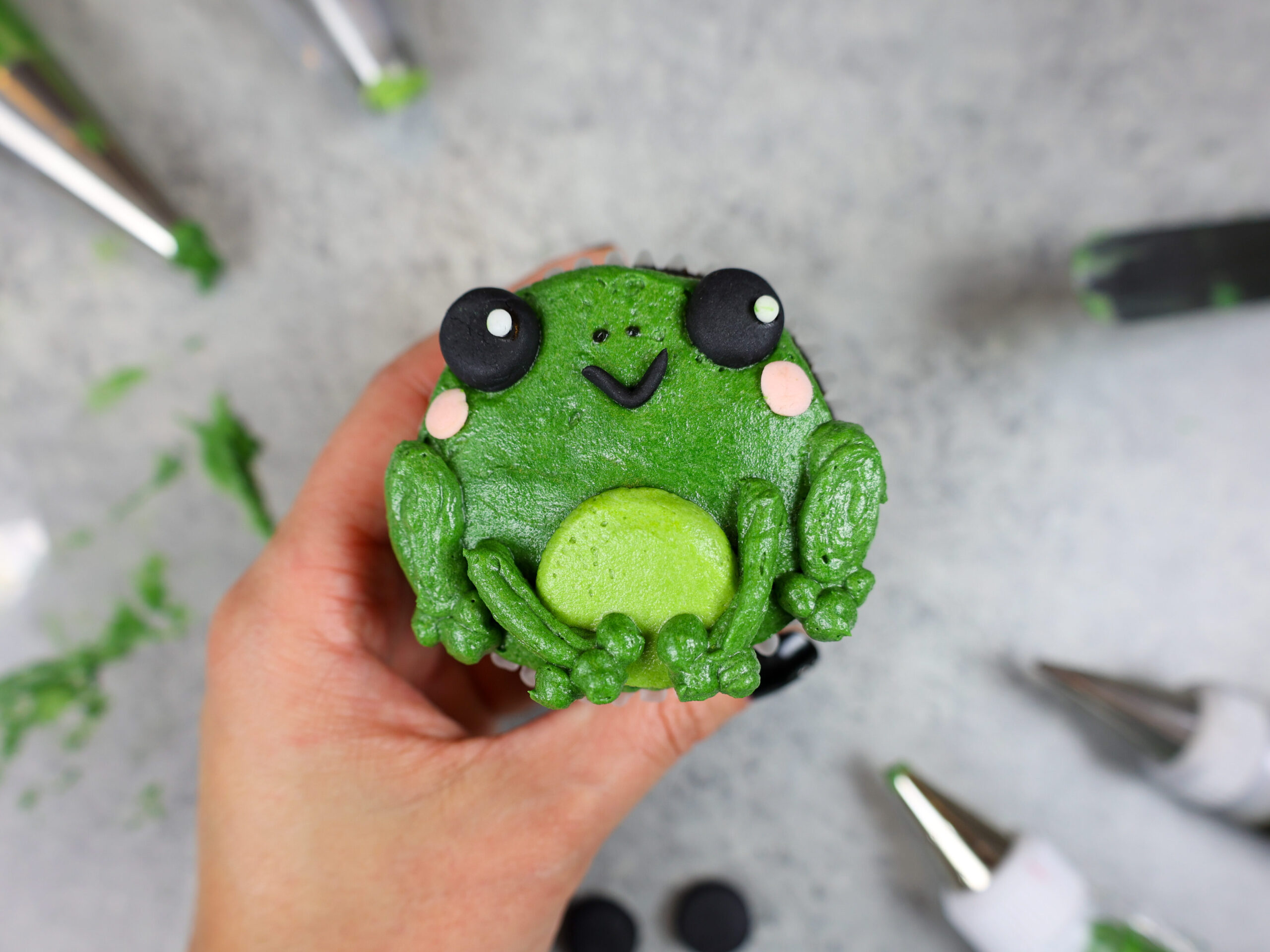 image of an adorable buttercream frog cupcake