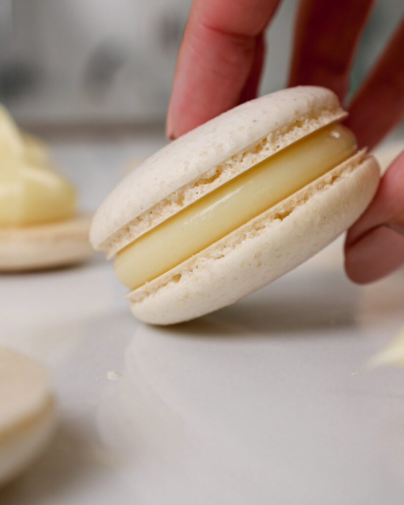 image of white chocolate ganache that's been used to fill a white macaron shell